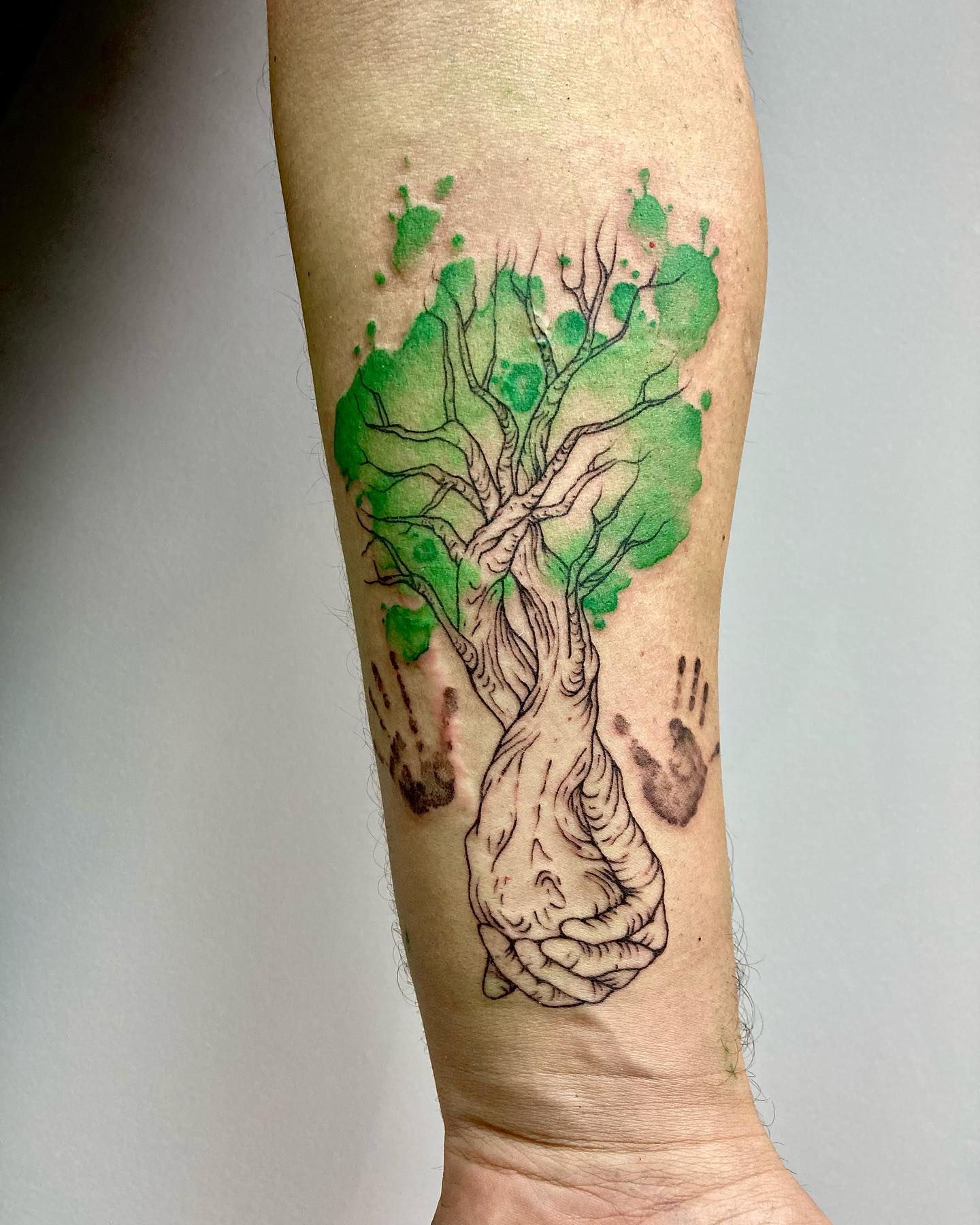 Tatuaje artístico del Árbol de la Vida salpicado de color.