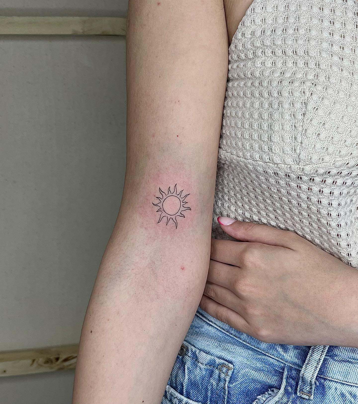 Diseño de tatuaje solar en antebrazo.