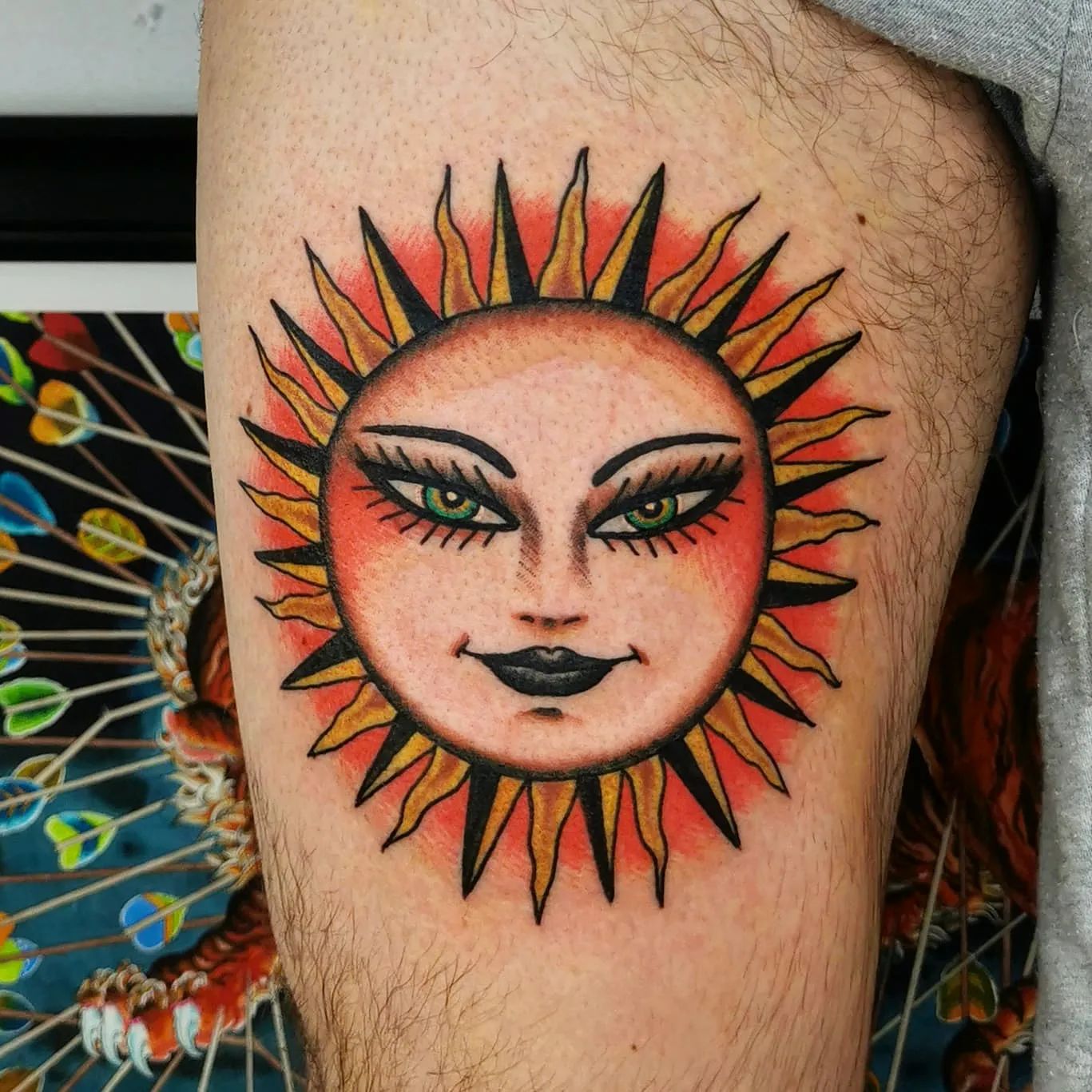 Tatuaje de sol en el muslo.