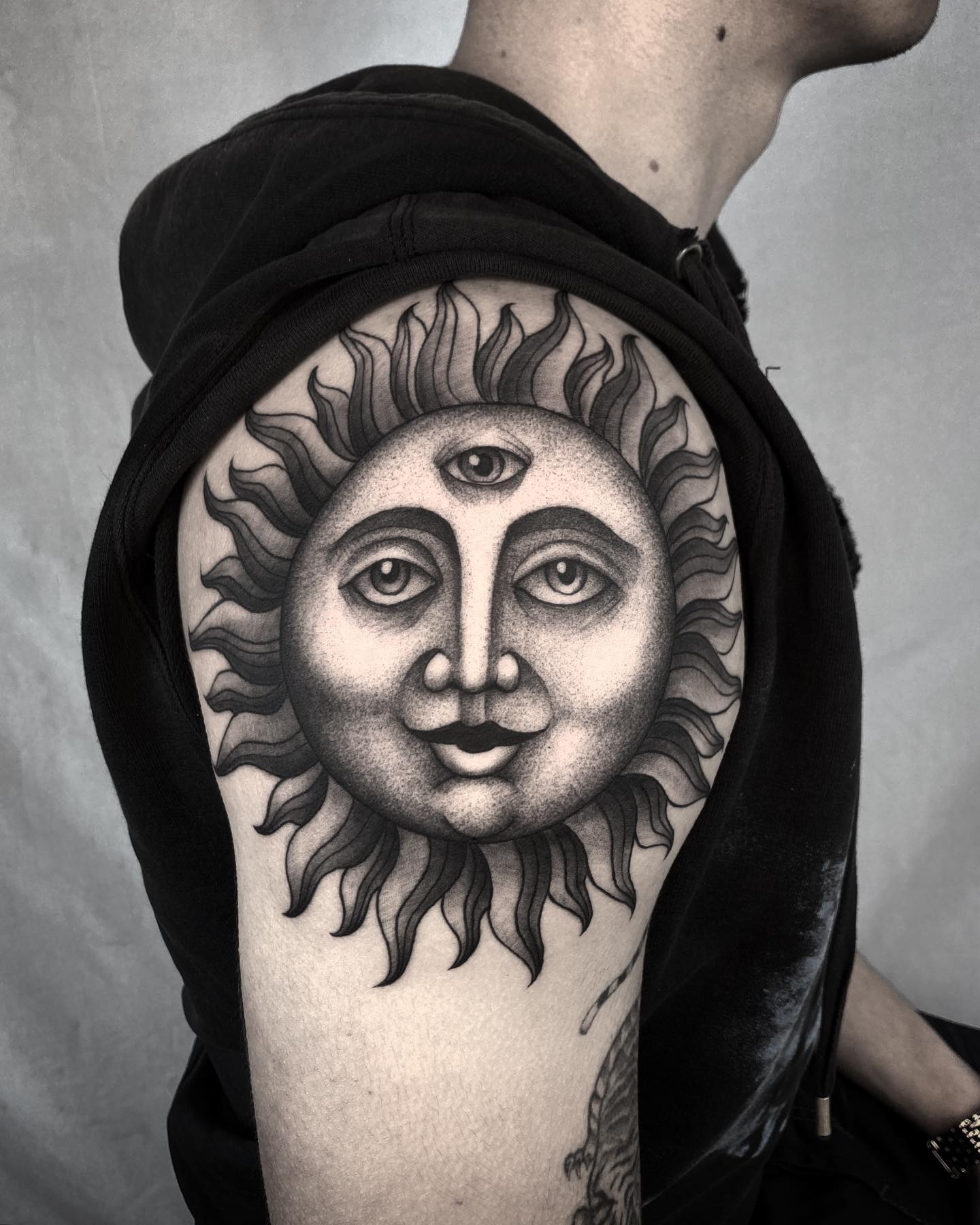 Tatuaje gigante de sol en el hombro.