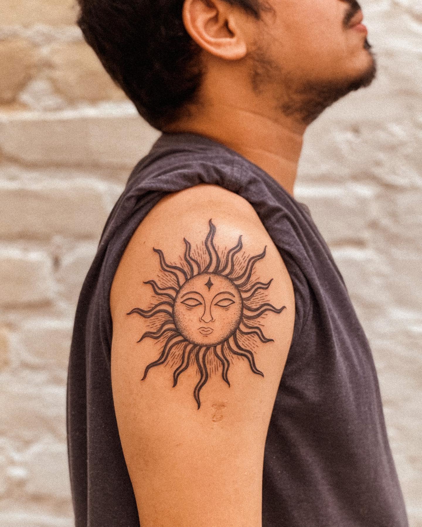 Tatuaje gigante de sol en los hombros